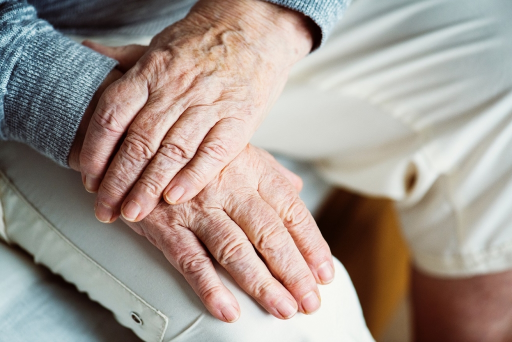 Photo of an elderly hand on top of another hand