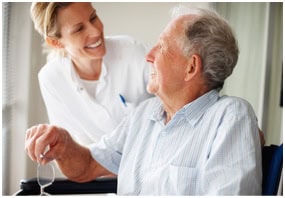 Photo of a skilled nurse assisting an elderly man with physical therapy